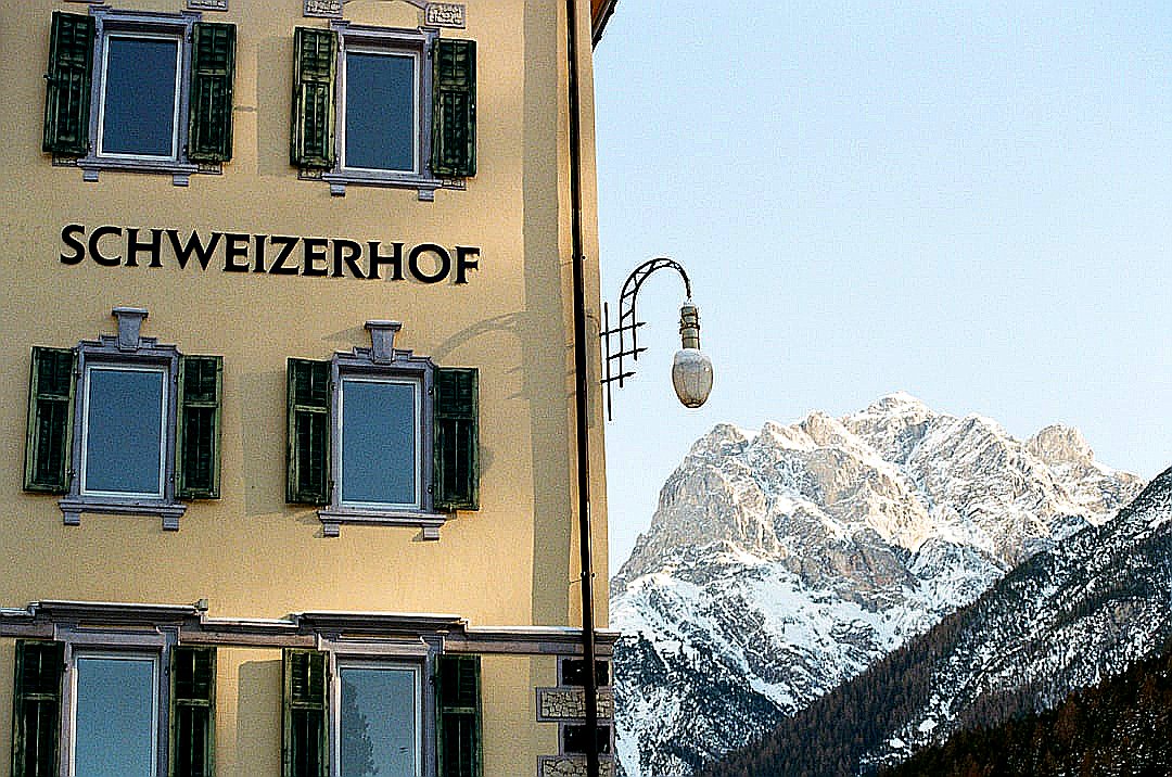 A tall yellow building with a mountain in the background