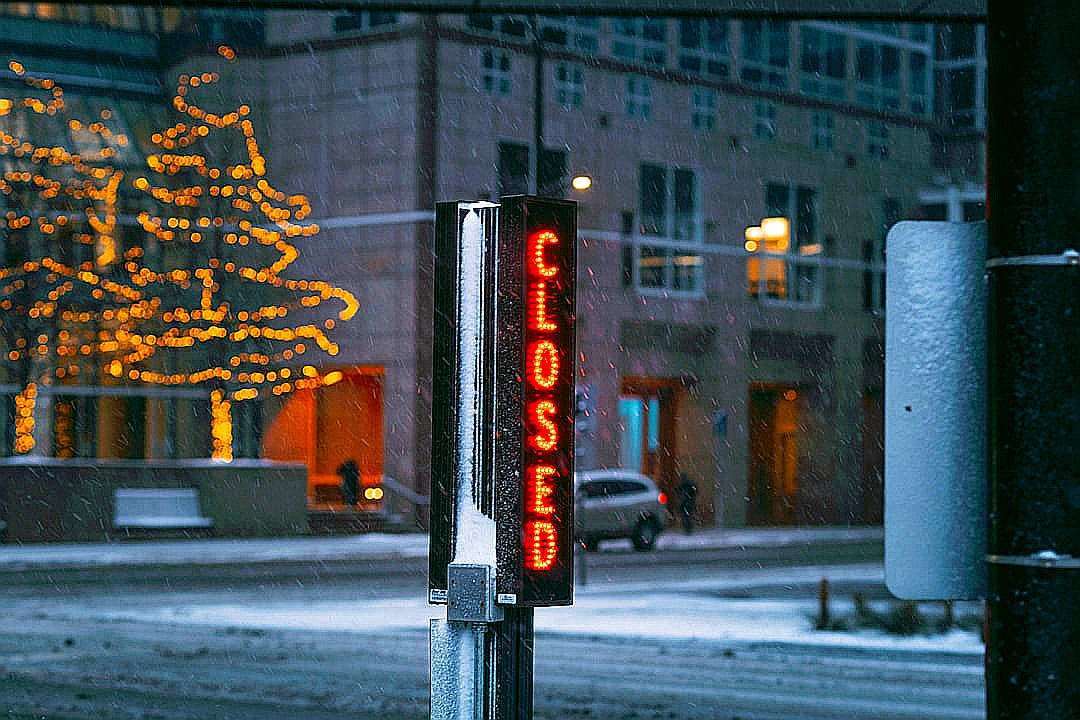 a street sign with a christmas tree in the background