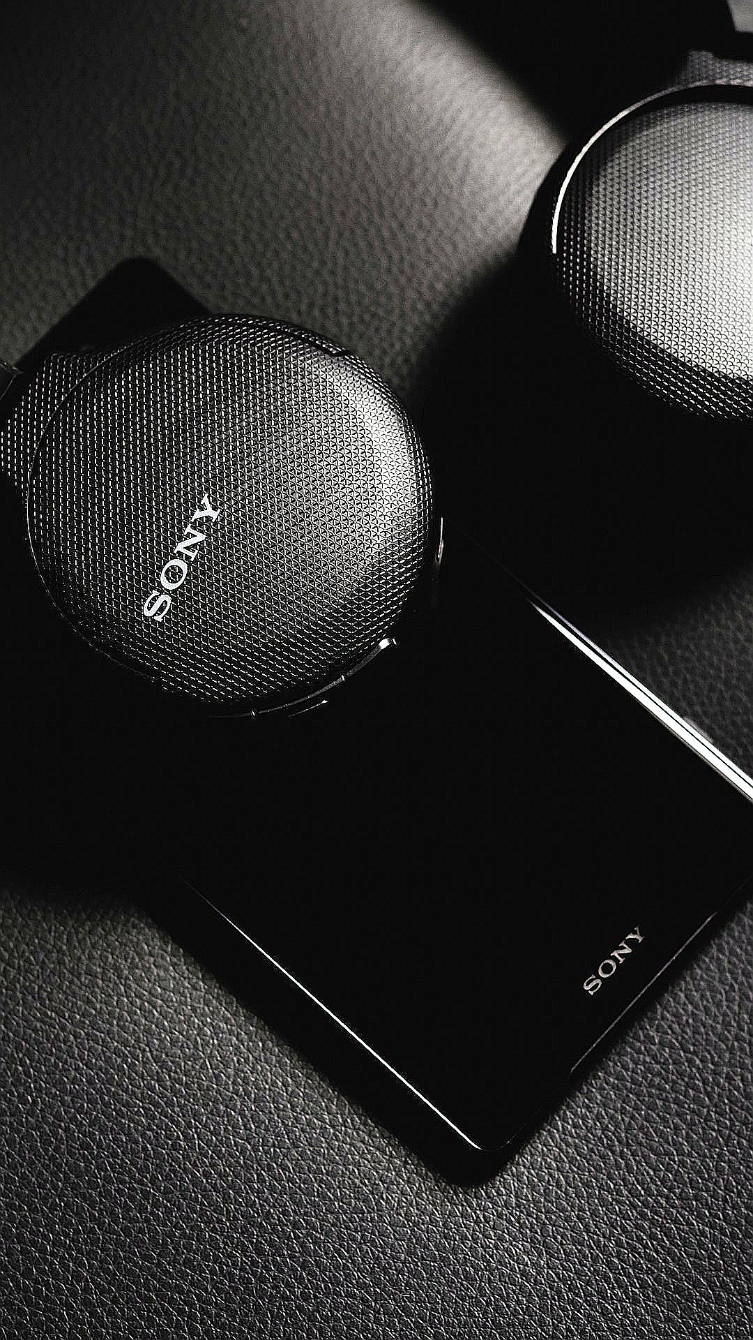 black sony portable speaker beside white smartphone