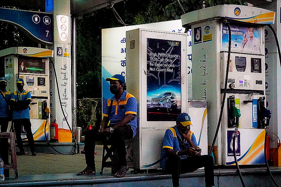 Gas station attendants sit near pumps
