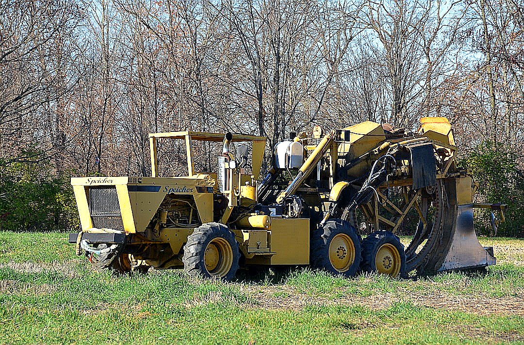 a tractor is parked in a field with trees in the background