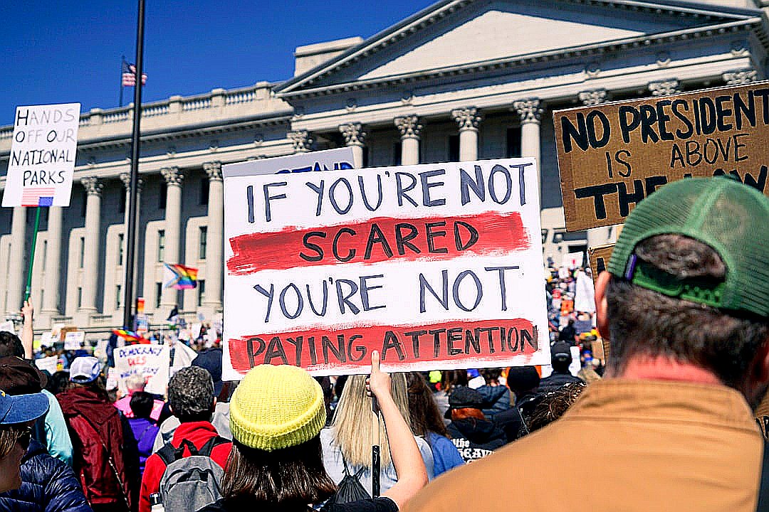 Protestors hold signs during a political demonstration.
