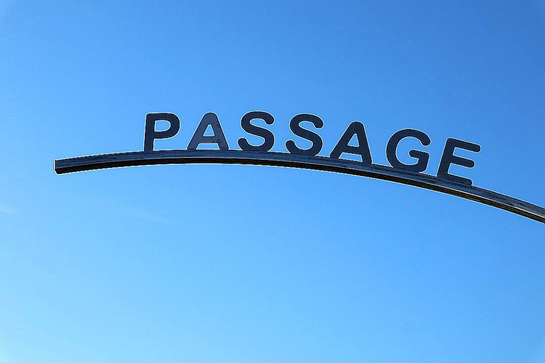 a street sign that reads passage under a blue sky