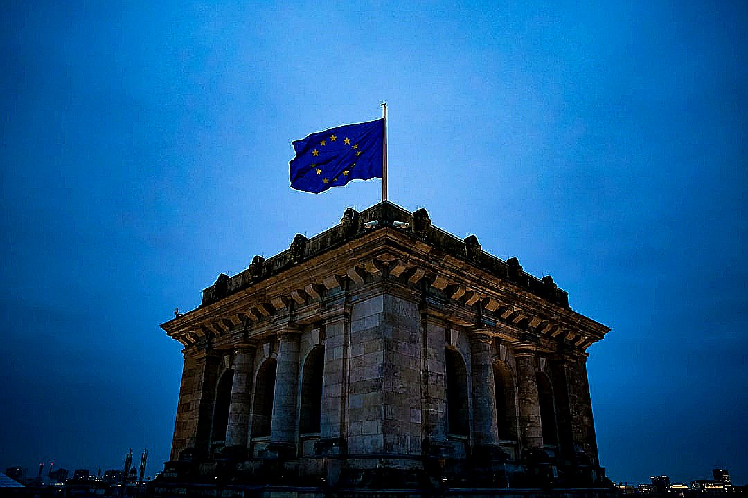 blue and white star flag on top of brown concrete building