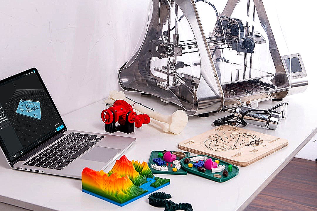 MacBook Pro beside 3D printer