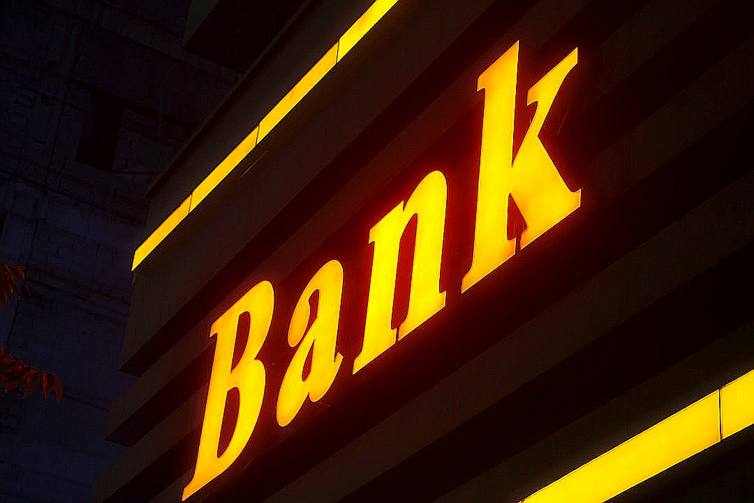 a bank sign lit up in the dark