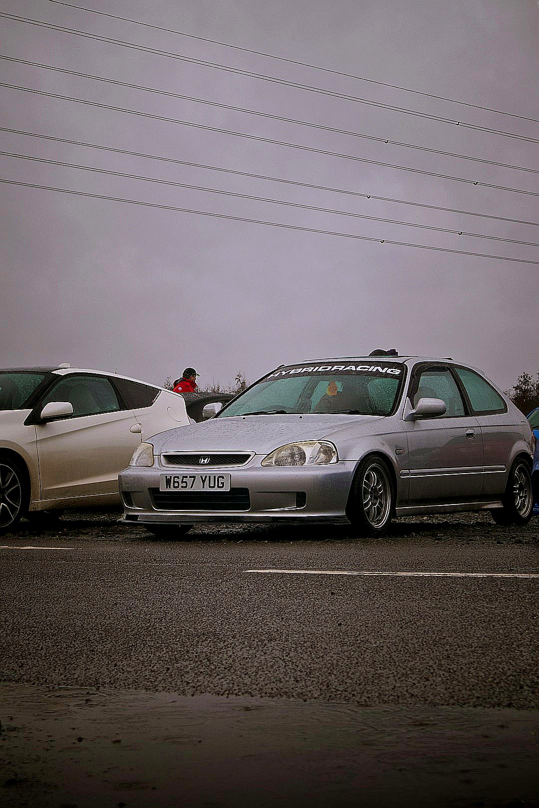 two cars parked next to each other in a parking lot