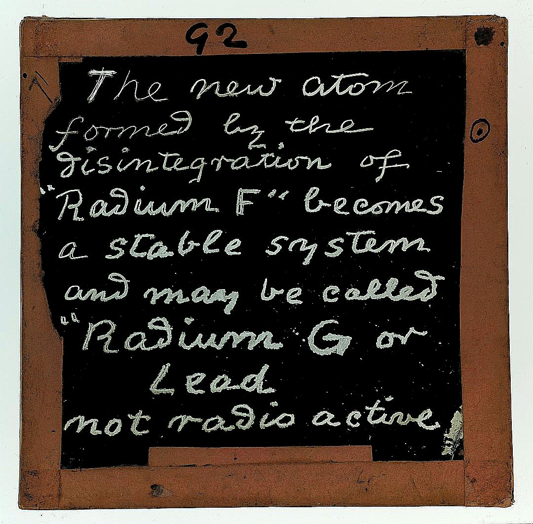 Handwritten text on a chalkboard about radioactivity.
