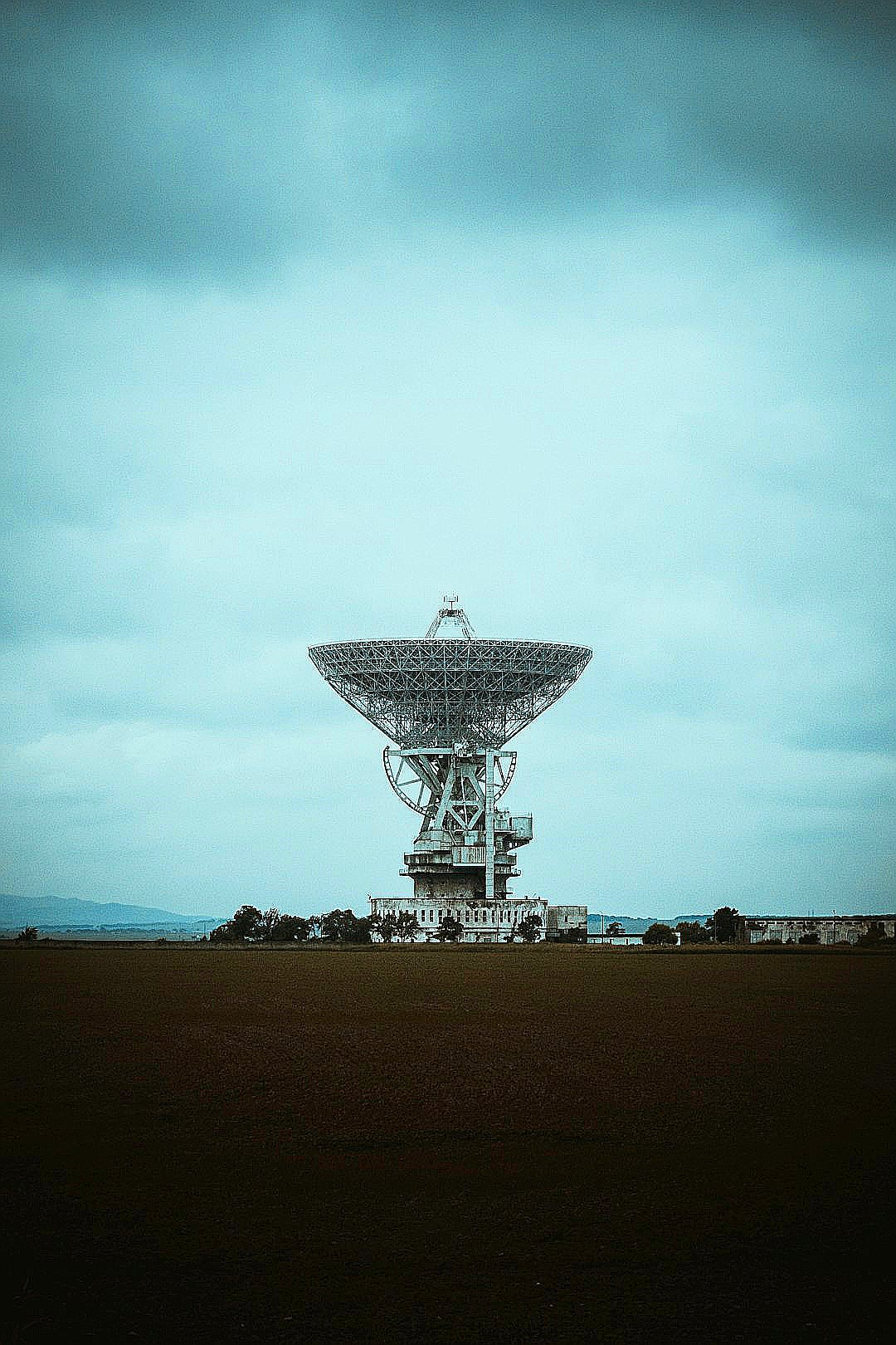 satellite dish on brown field under white clouds and blue sky during daytime