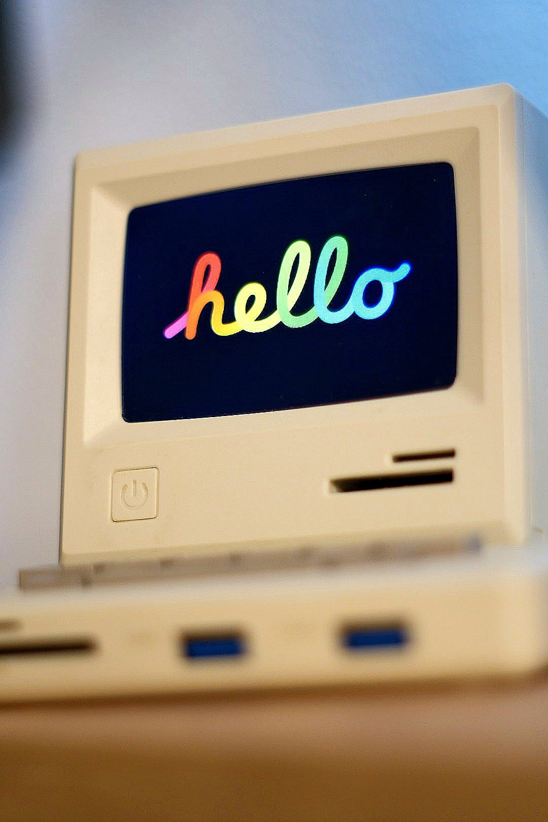 A miniature retro computer displaying "hello" on its screen