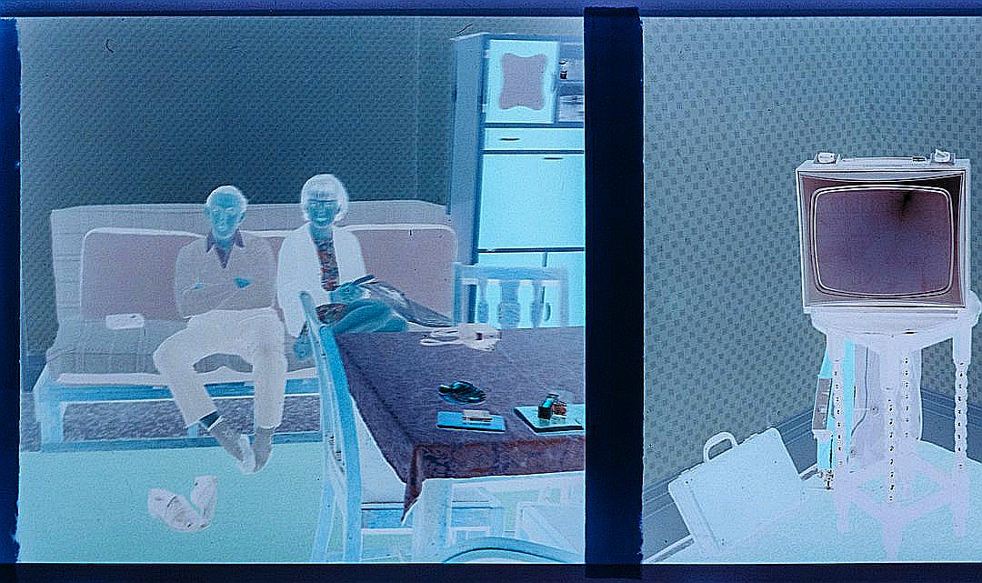 Two people sit on a couch in a room